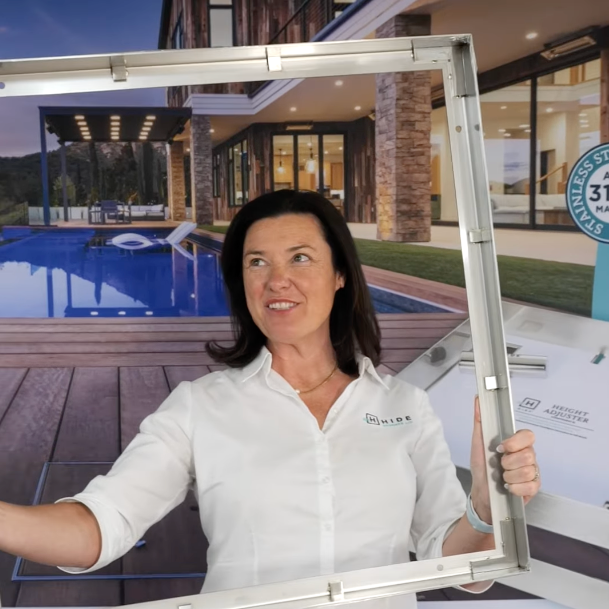 HIDE representative SJ holding a large stainless steel HIDE 656 Drain Cover recess frame, shown in a poolside display setting.