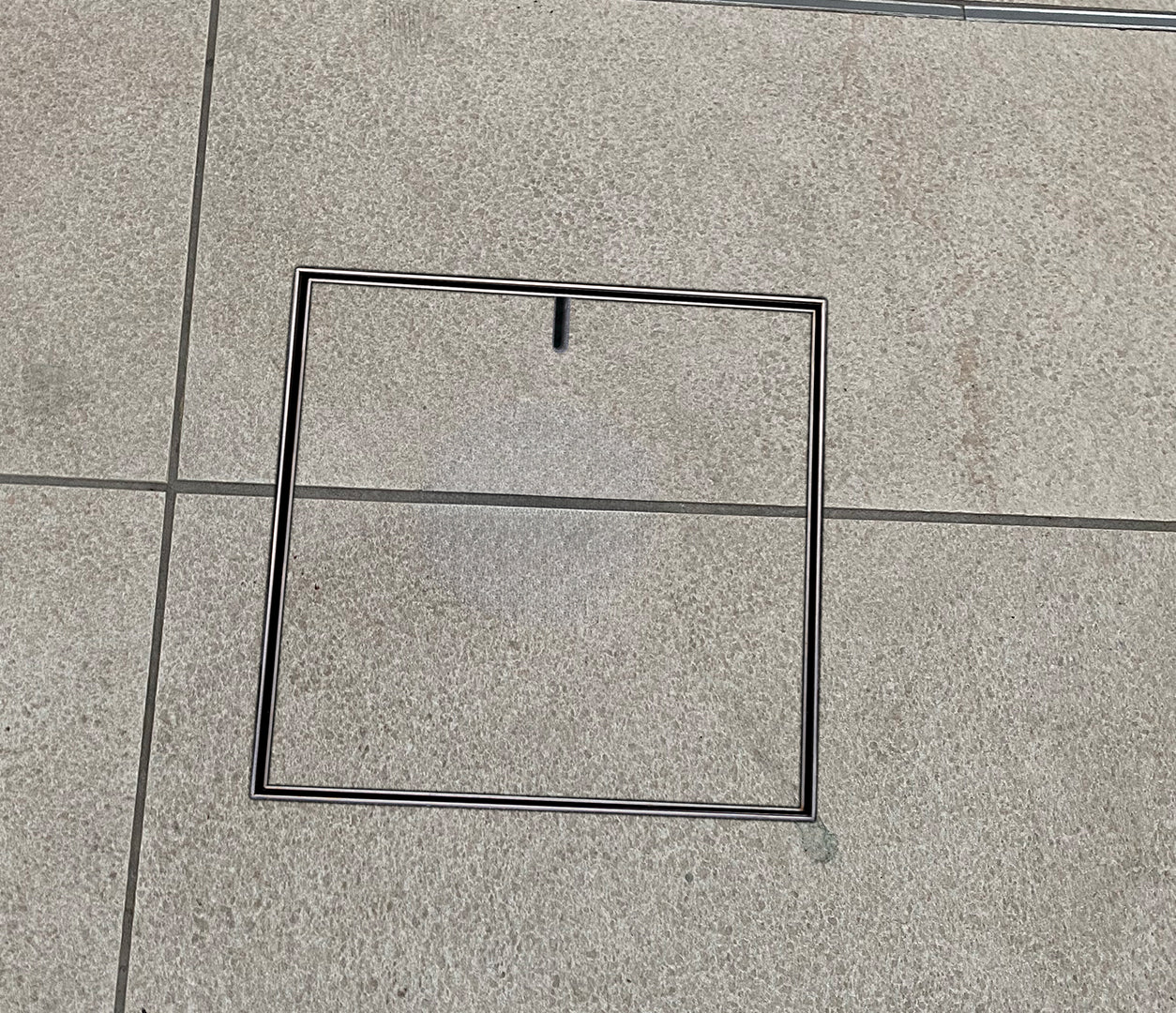 HIDE Drain Cover with tile inlay, grout and tile running through cover for a seamless finish.