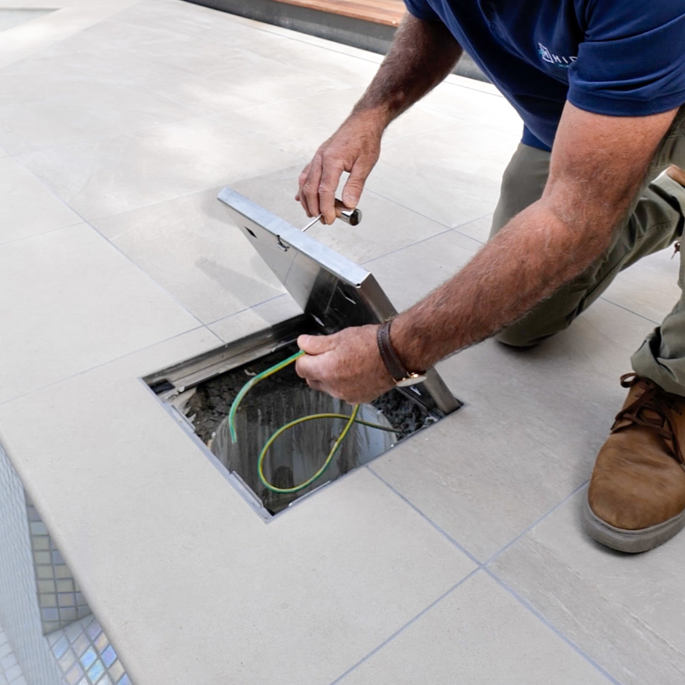 HIDE Skimmer Cover being lifted showing the grounding/earthing wire underneath.