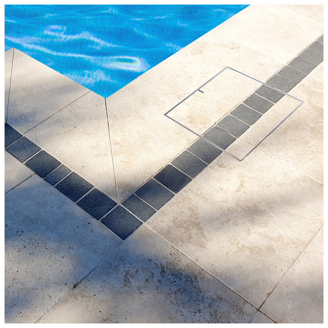 HIDE Skimmer Lid installed to continue the paving pattern around a pool.