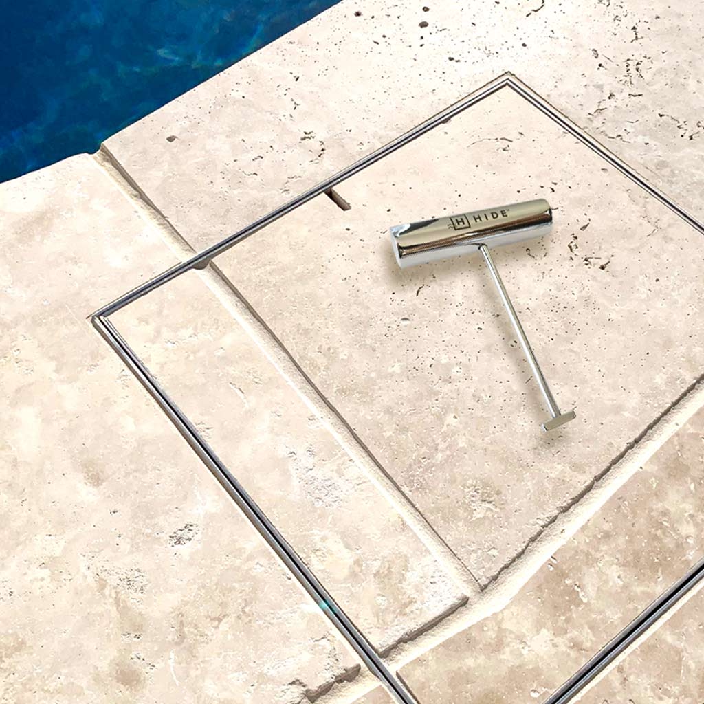 HIDE Skimmer Cover installed flush in pool tile coping with stainless steel safety lifting key.
